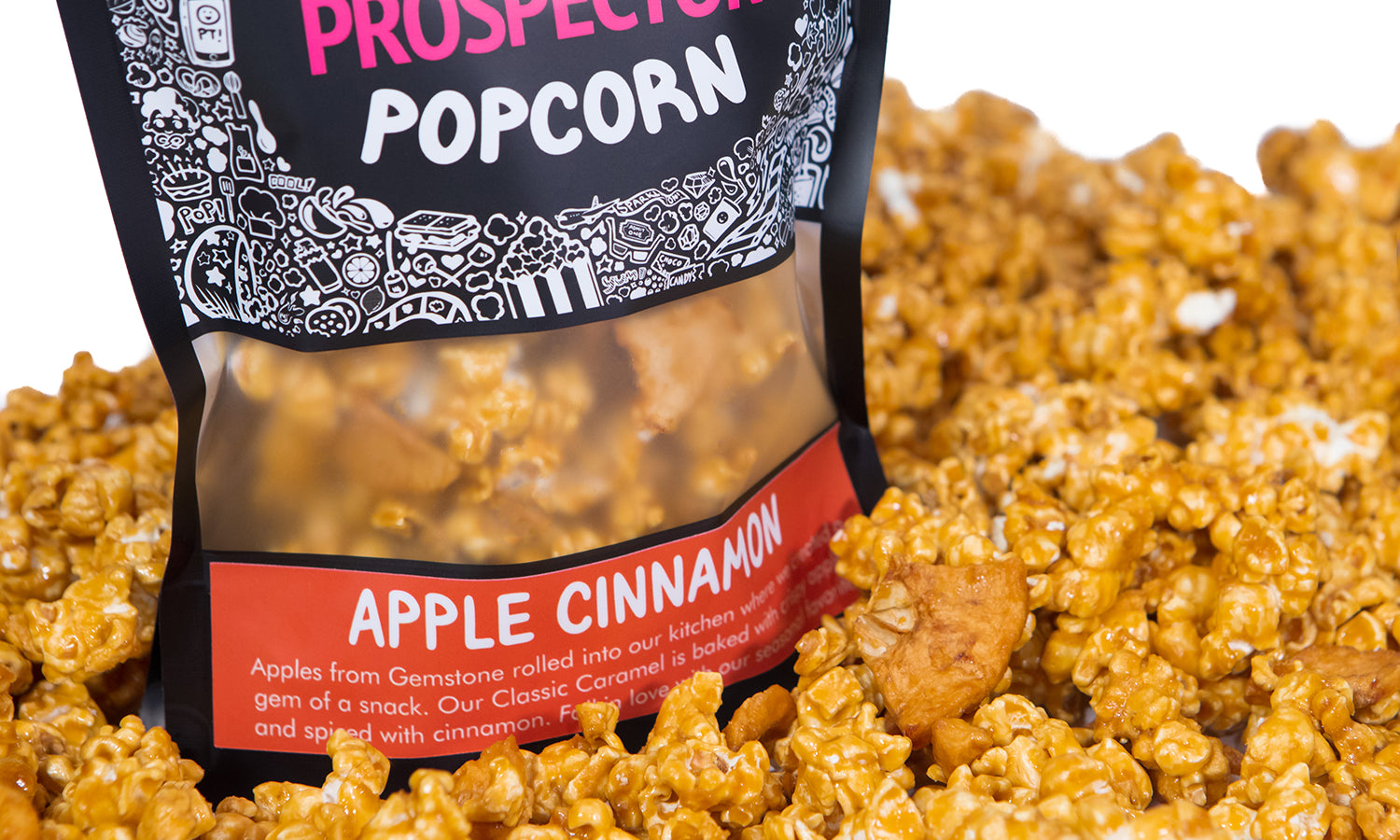 A bag of Apple Cinnamon Prospector gourmet popcorn  sits in a pile of its own popcorn.