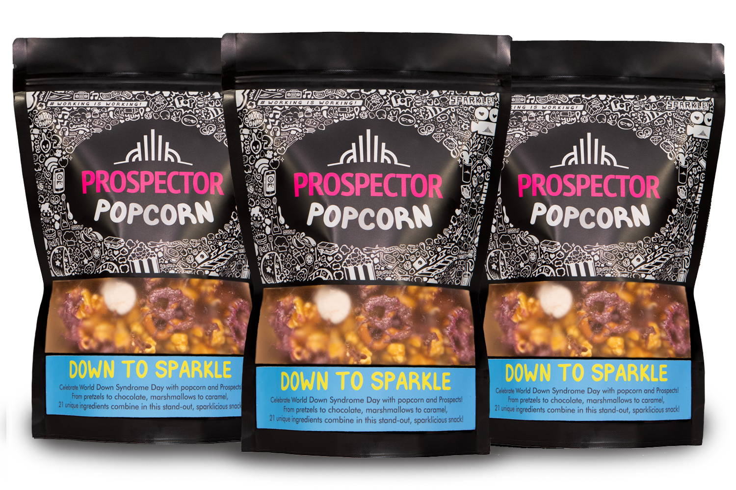 Three bags of Prospector Popcorn are lined up side by side. The packaging is black with white decorative patterns and features the product name. The flavor is "Down to Sparkle," described as caramel popcorn with chocolate, marshmallow, and sprinkles.