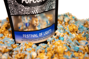 A bag of Festival of Lights gourmet Prospector Popcorn sits in pile of its own popcorn