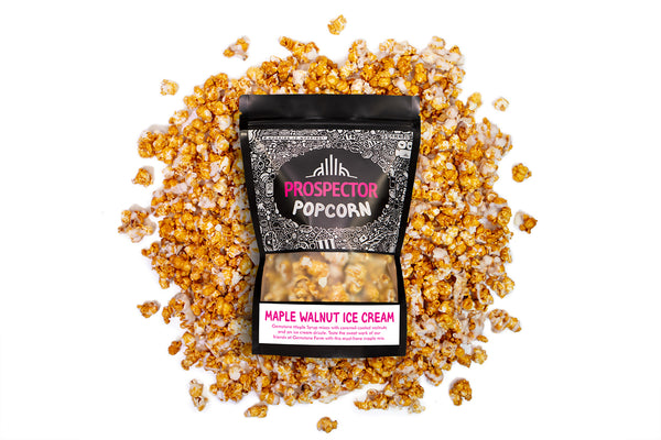 A bag of Maple Walnut Ice Cream popcorn lays on a pile of its popcorn.