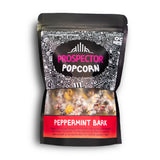 A bag of Peppermint Bark gourmet Prospector Popcorn sits on a white background.