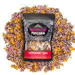 A bag of Peppermint Bark gourmet Prospector Popcorn lays on a pile of its own popcorn.