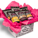 A gourmet popcorn gift box sits on a white background to show off the sweet flavors inside