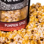 A bag of Pumpkin Spice gourmet popcorn sits in a pile of its own popcorn