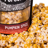 A bag of Pumpkin Spice gourmet popcorn sits in a pile of its own popcorn