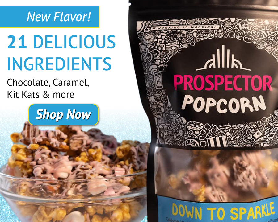 A promotional image for Prospector Popcorn's new flavor, "Down to Sparkle." The popcorn package is shown with popcorn drizzled in chocolate and topped with various sweets. Text highlights "21 Delicious Ingredients." A "Shop Now" button is included.