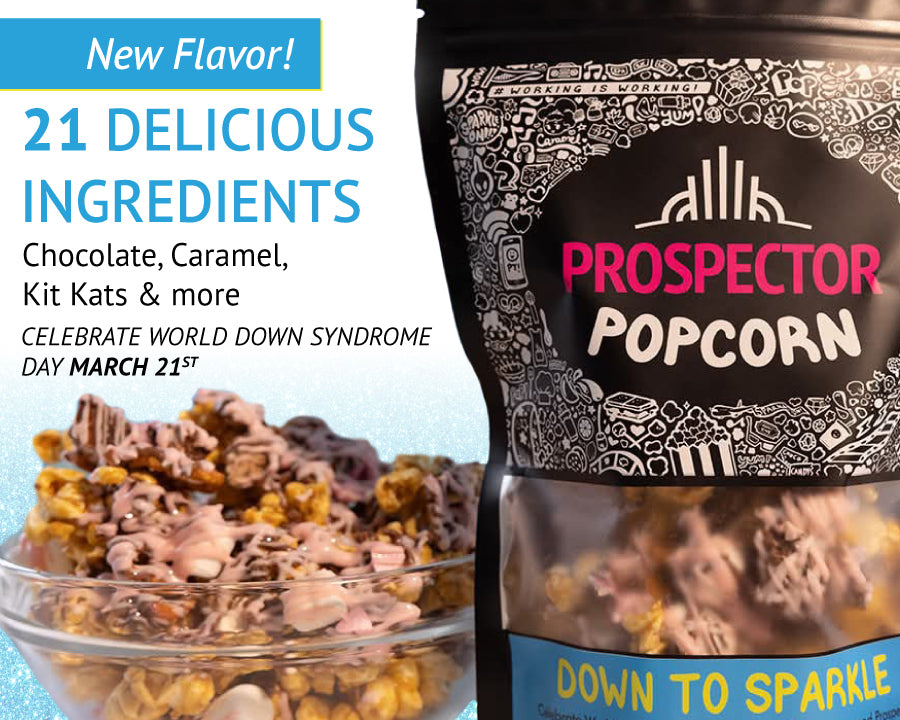 A bag of Prospector Popcorn, labeled "Down to Sparkle," is shown with popcorn spilling out. Text highlights a new flavor with 21 ingredients, including chocolate, caramel, and Kit Kats. It mentions celebrating World Down Syndrome Day on March 21st.