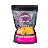 A bag of Maple Bacon Cheddar Bacon Gourmet Popcorn sits on a white background