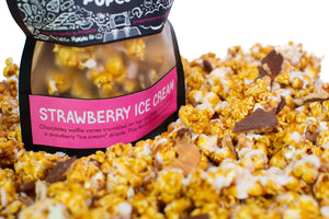 A bag of Strawberry Ice Cream gourmet popcorn sits in a pile of its own popcorn