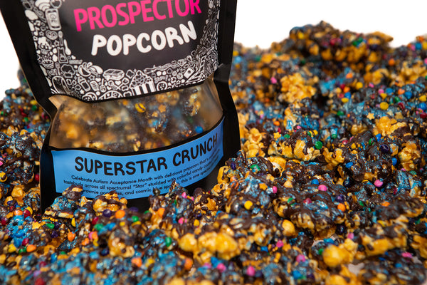 A bag of Superstar Crunch popcorn sits within a pile of its own popcorn